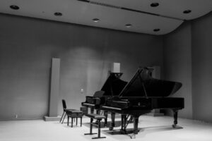 Elegant black and white photo of a grand piano in an empty concert hall in Montreal.